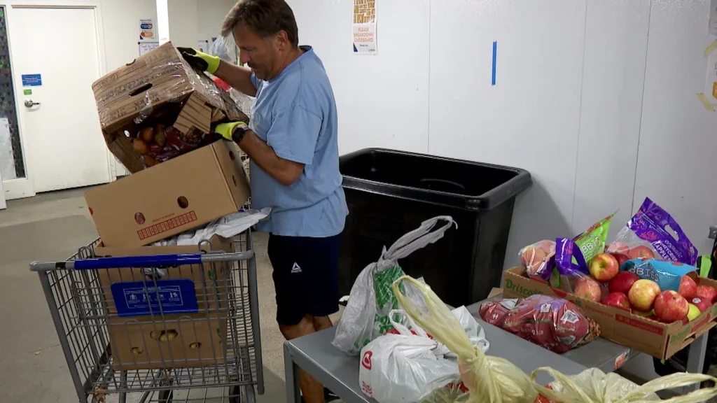 Tim Tapper sorts fresh produce behind PRISM’s food distribution space.